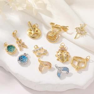 Assorted 14K gold plated zircon pendants featuring Eiffel Tower and leaf designs