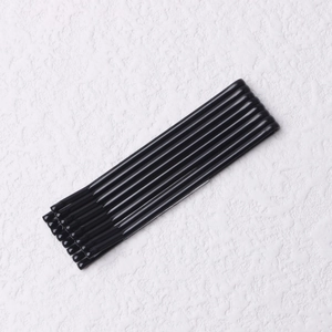 Macro shot of seven smooth black metal hair pins on a white textured surface