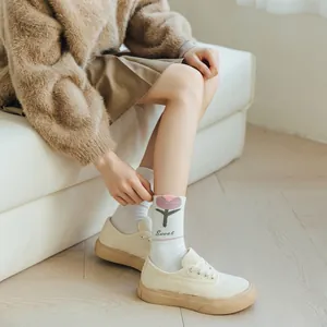 Detail of white cotton socks with pink floral embroidery and comfortable elastic cuffs