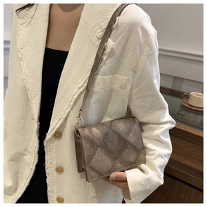 Detail of a vintage quilted crossbody bag in metallic grey with elegant shoulder strap