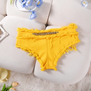 Dettaglio di pantaloncini di jeans gialli con bordi sfrangiati a mano e vita di strass