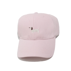 Detailed embroidery of a white dachshund on a light pink cotton baseball cap fabric