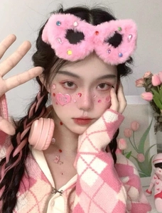 Detailed view of a pink plush headband with colorful rhinestones on a female model