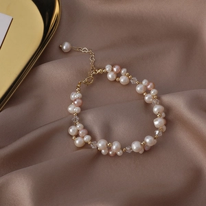 Detail of freshwater pearl bracelet with gold beads and crystal on silk background