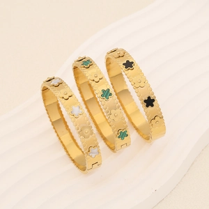 Tre bracciali in acciaio inossidabile dorato con fiori colorati su fondo bianco
