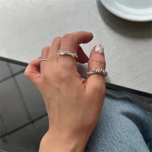 Close-up of stacked 925 sterling silver minimalist rings with wavy and beaded textures