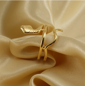 Detailed view of adjustable golden snake ring nestled in luxurious silk satin fabric