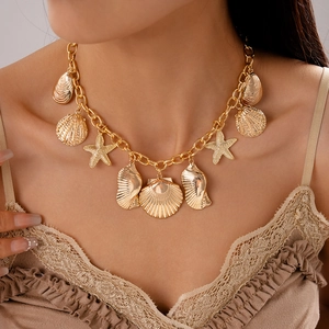 Detailed close-up of golden starfish and seashell layered necklace worn by a fashion model