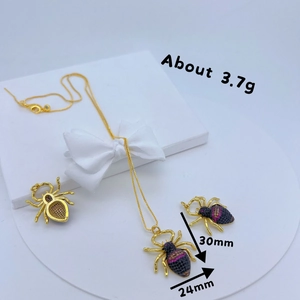 Golden spider jewelry set with purple zircon pendant and matching stud earrings