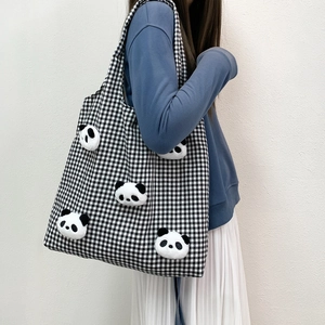 Checkered canvas tote bag featuring 3D panda plush dolls shown on shoulder with outfit