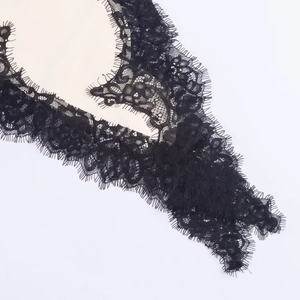 Gros plan sur la dentelle noire raffinée aux cils de la robe à bretelles asymétrique