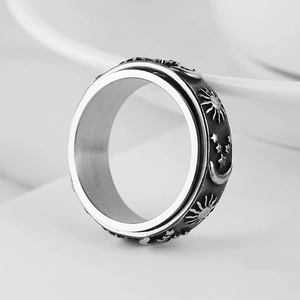 Detail of rotating outer band with sun moon and star engravings on steel ring