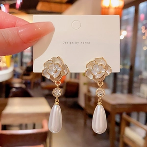 Detailed macro view of camellia flower earrings with water drop pearls and zircon accents