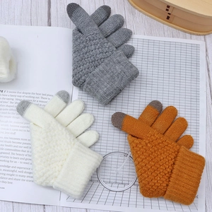 Close-up of knit winter gloves in grey white and orange with touchscreen finger tips