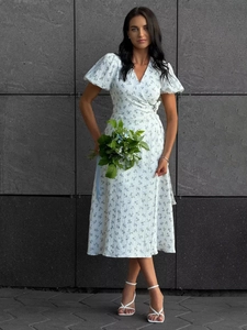 Detailed wrap dress with blue floral print, puff sleeves, and side tie waist design
