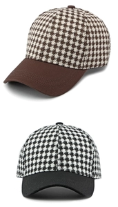 Detail of houndstooth pattern fabric on retro baseball caps in brown and black