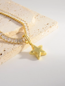 Detailed macro view of a gold-plated star pendant with cubic zirconia inlay necklace