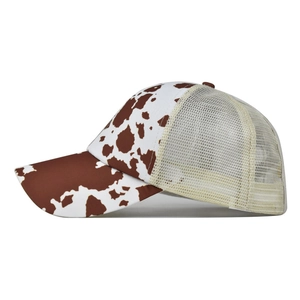 Detail of cow print trucker hat featuring brown and white patterns and breathable mesh