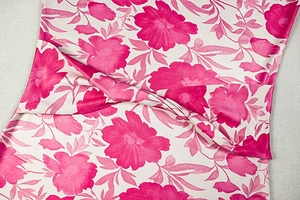 Gros plan sur la texture du tissu imprimé floral rose d'une robe longue ajustée