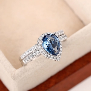 Detail eines birnenförmigen blauen Zirkonia-Rings mit zweischichtigem Pavé-Band