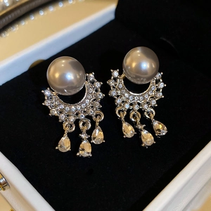 Macro shot of silver pearl tassel earrings with micro-set diamonds and zircon drops