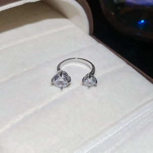 Détail d'une bague en U argentée avec zircons étincelants dans un écrin en velours