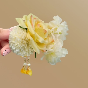 Detailed macro shot of yellow fabric rose hair clip with elegant pearl tassel pendant