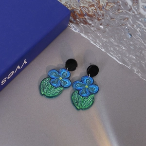 Minimalist summer blue flower earrings with green leaves on a textured wave background
