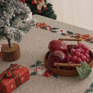 Close-up of festive Christmas embroidery on textured linen tablecloth with holiday decor