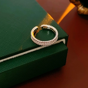 Détail de bague argentée sertie de zircons sur un écrin à bijoux vert texturé