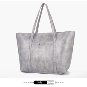 Detail view of the gray-blue textured faux leather tote bag with front pocket