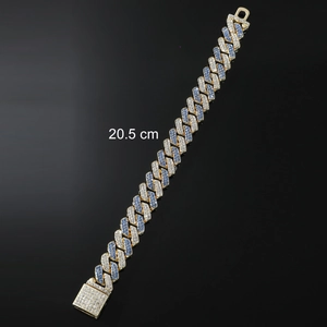 Macro shot of gold hip hop Cuban link bracelet with blue and white zircons and 20.5 cm size mark