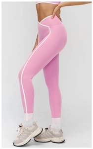 Dettaglio dei leggings da yoga rosa con vita a V incrociata e strisce laterali bianche a contrasto