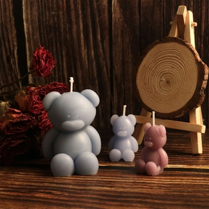 Drie beervormige geurkaarsen in mat blauw, paars en roze op rustieke houten decor