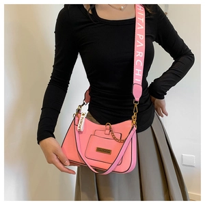 Detail of pink crossbody bag with wide logo strap and gold chain on model