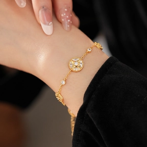 Detailed view of 18K gold plated bracelet with starburst zircon on a woman wrist