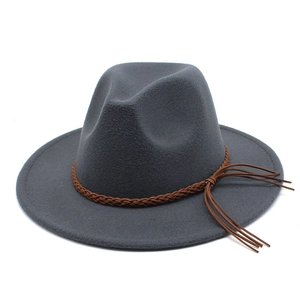 Detail of dark grey wool fedora hat featuring a brown braided band and side tassel accents