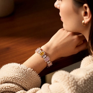 Close-up of rose gold bracelet with pink and yellow square-cut crystals on model's wrist
