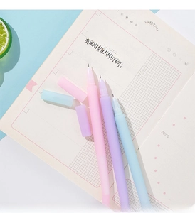 Three-pack of pastel macaron jellyfish pens resting on a notebook for daily journaling