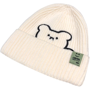 Cream knit beanie with cute bear embroidery and green side label for winter warmth