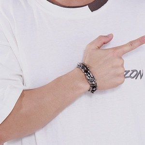 Macro detail of men's punk keel chain bracelet with vintage silver dragon relief pattern