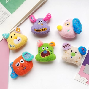 Detail view of six colorful plush dog head charms with embroidered DOG and HI text