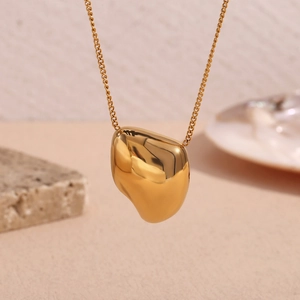 Close-up of polished gold organic teardrop pendant with minimalist O-chain necklace