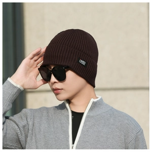Close-up of coffee brown ribbed knit beanie with small brand label and premium texture