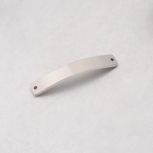Macro view of a polished stainless steel curved bar connector with dual end holes