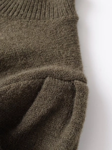 Gros plan sur le tissu tricoté vert olive montrant la texture côtelée et la laine douce