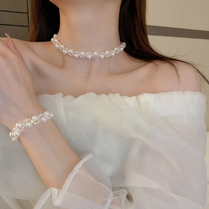 Detail of French vintage faux pearl and crystal necklace set on female model neckline