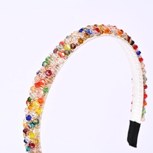Detail of colorful handmade crystal beads on a slim rainbow headband with white fabric base