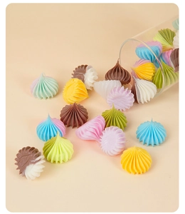 Macro view of assorted pastel resin meringue treats spilling from a glass jar for DIY crafts
