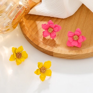 Matte rose red and yellow layered flower earrings on a minimalist wooden tray display